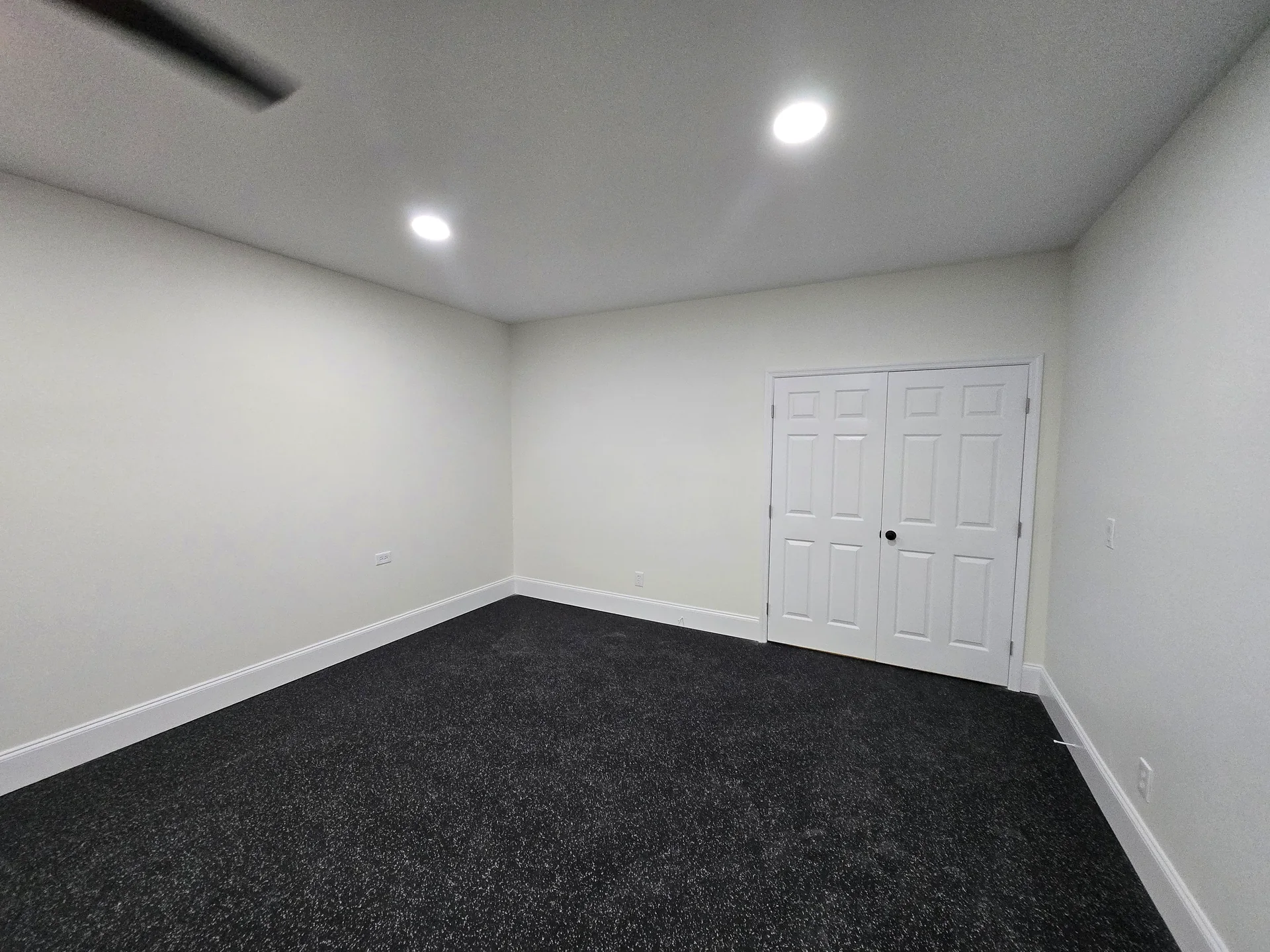 Carpeted basement flex room with fresh paint and recessed lighting
